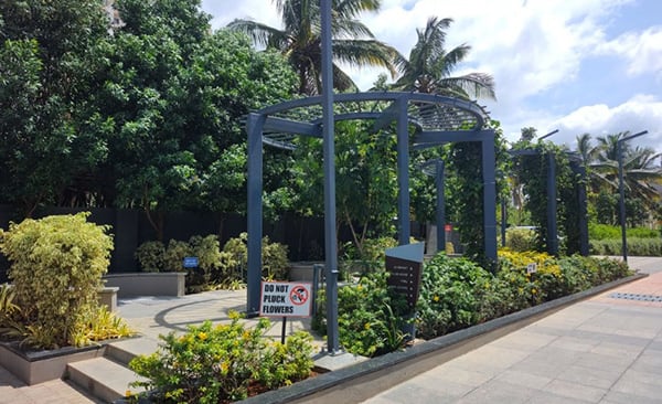Sattva Bliss waiting area with a pergola and planting, site photo