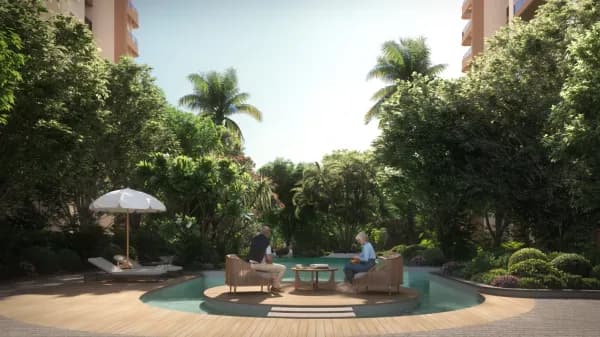 A round pool deck with seating under the trees at Sattva City, artist's impression