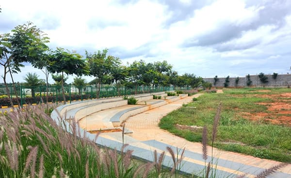 A planted walk beside civic amenity sites 5, 6 and 7 at Sattva Green Groves, site photo, September 2026