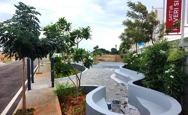 Curved seating being finished in Park 13 beside an internal road, construction photo, September 2026