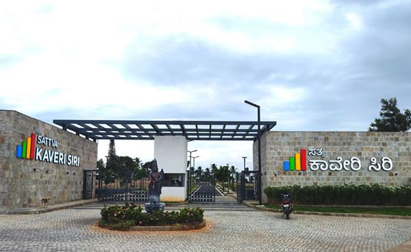 The built entry portal of Sattva Kaveri Siri with its English and Kannada signage, construction photo, September 2026