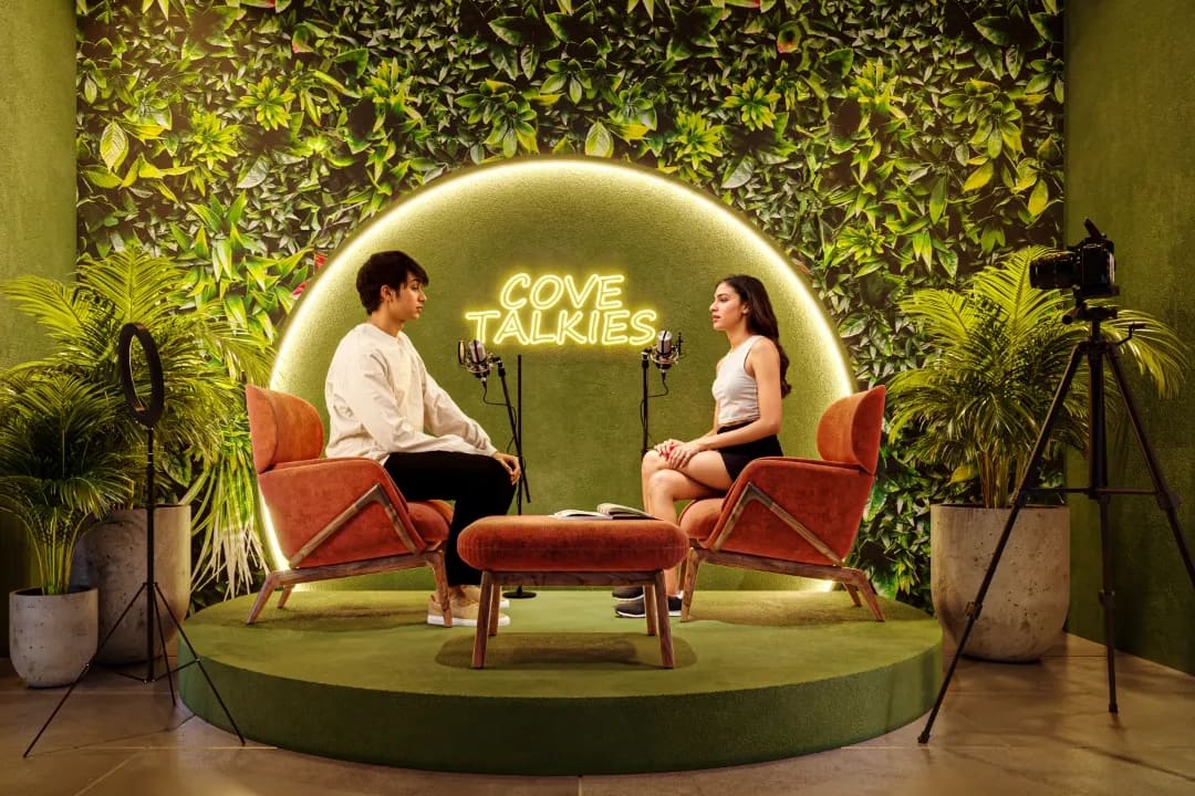 Cove Talkies, the influencer zone: a podcast set under a glowing arch on a green moss wall, artist's impression