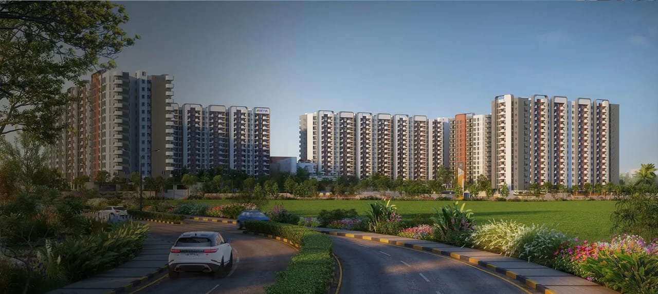 Sattva Vasanta Skye towers beyond a green field and a landscaped approach road, artist's impression